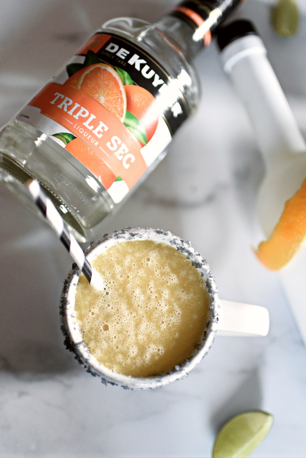 Halloween Orange Mango Jalapeno Margaritas with black lava salt featuring Gem & Bolt Mezcal served in ghost mugs from Pottery Barn. #gemandbolt #gemandboltmezcal #mezcalcocktail #mezcalmargarita #halloweenmargarita #halloweencocktail #ghostmug