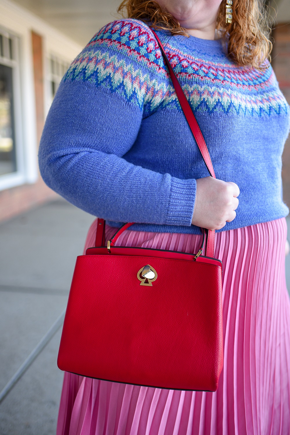 A Festive Holiday Outfit Formula: a plus size outfit featuring a Christopher and Banks fair isle sweater, an H&M pleated skirt, and Kendra Scott earrings. #christopherandbanks #holidayoutfit #christmasoutfit #holidayfashion #holidaystyle #katespadebag #whiteboots