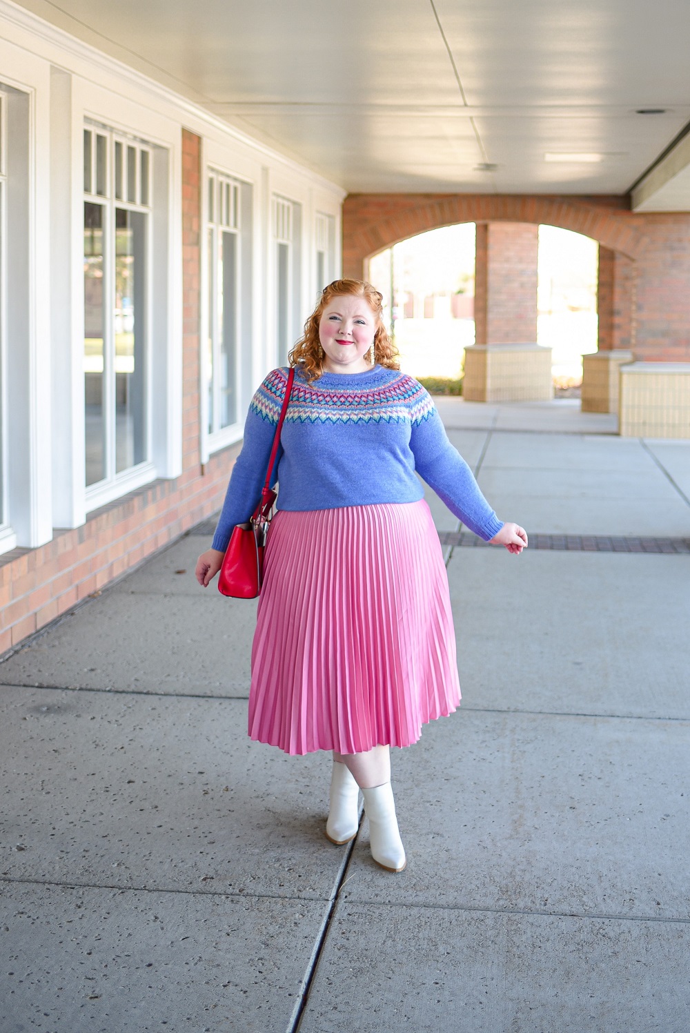 A Festive Holiday Outfit Formula: a plus size outfit featuring a Christopher and Banks fair isle sweater, an H&M pleated skirt, and Kendra Scott earrings. #christopherandbanks #holidayoutfit #christmasoutfit #holidayfashion #holidaystyle #katespadebag #whiteboots