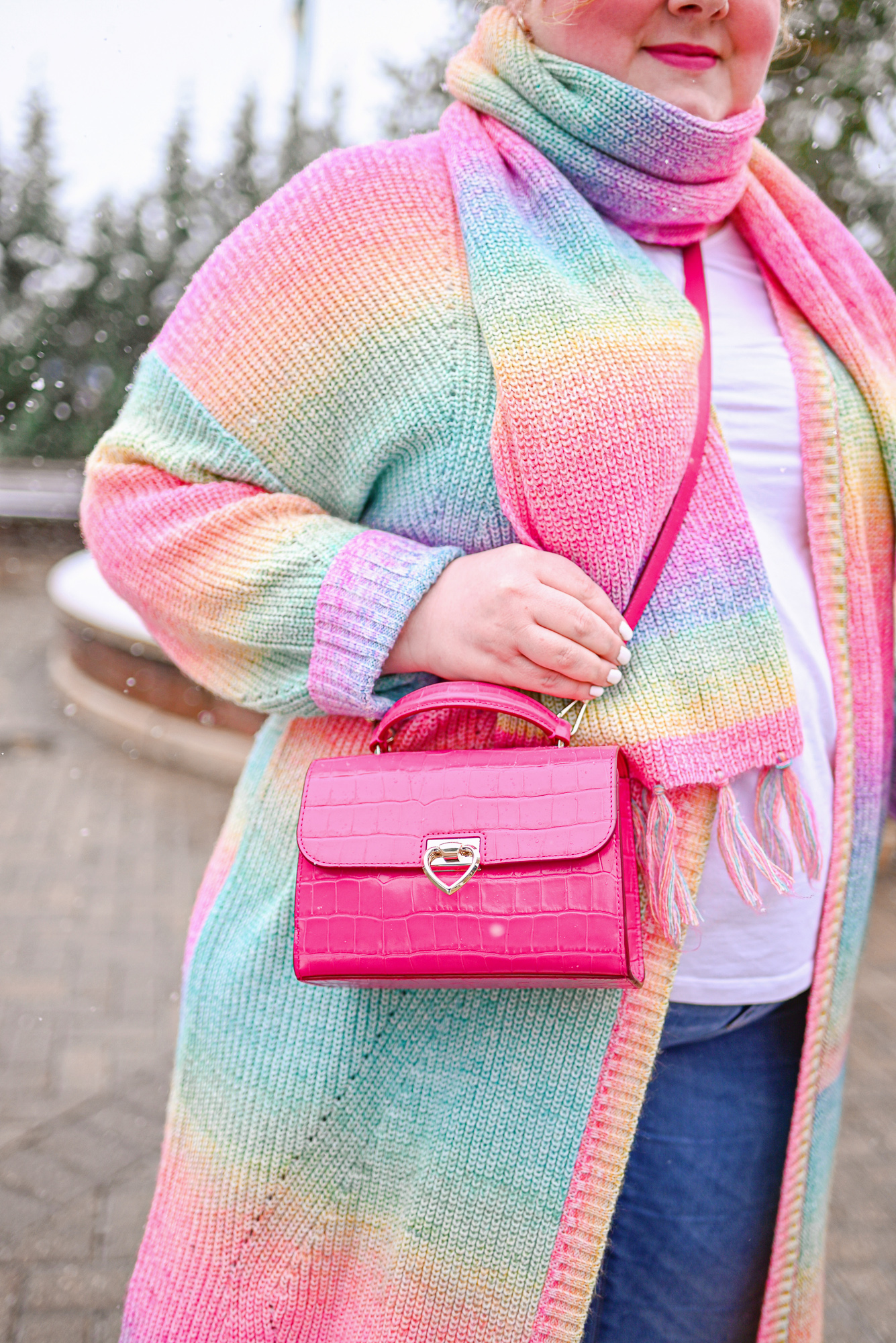 A Colorful Winter Outfit from Torrid: style their rainbow duster and matching scarf with a white tee, skinny jeans, and white booties.
