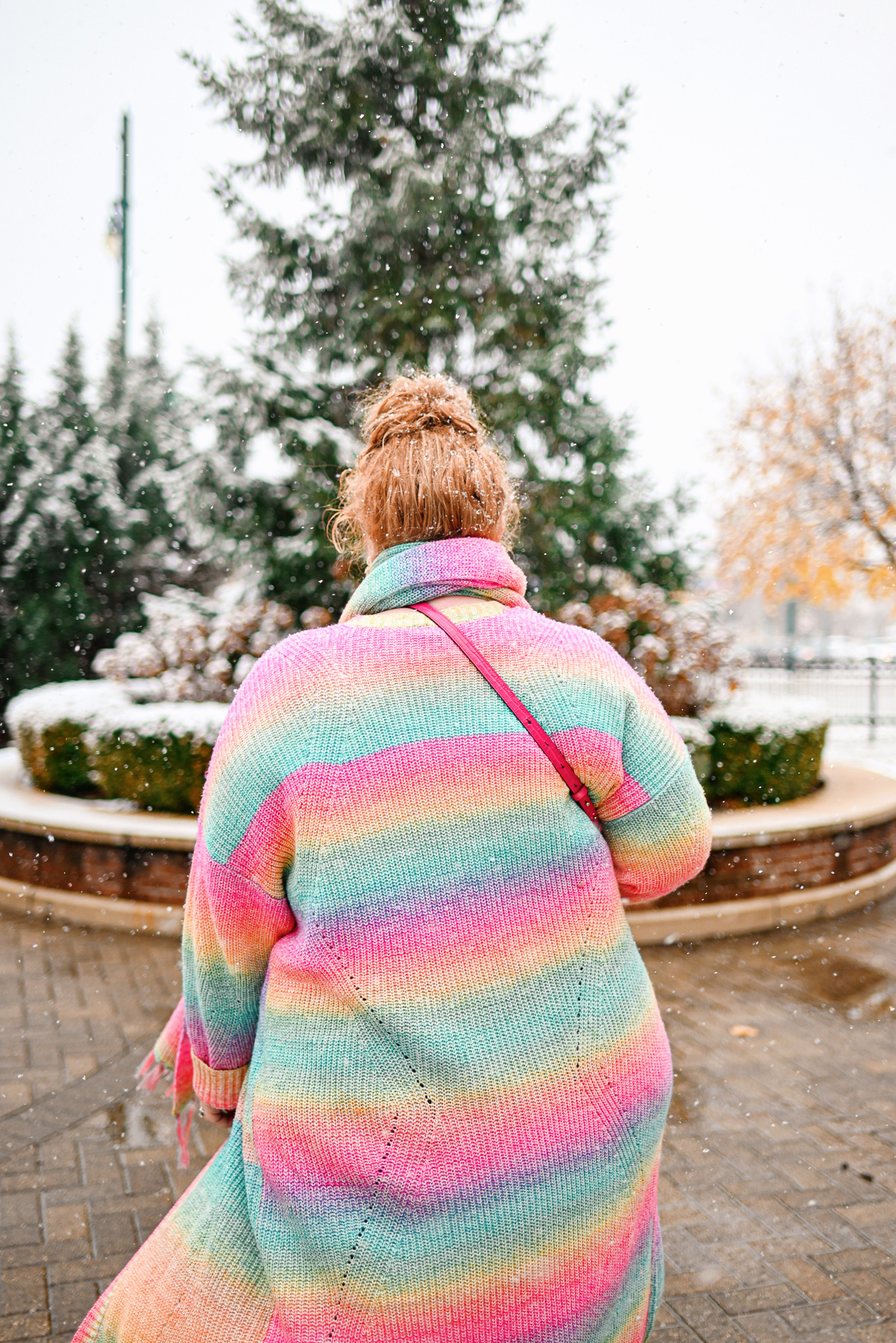 A Colorful Winter Outfit from Torrid: style their rainbow duster and matching scarf with a white tee, skinny jeans, and white booties.