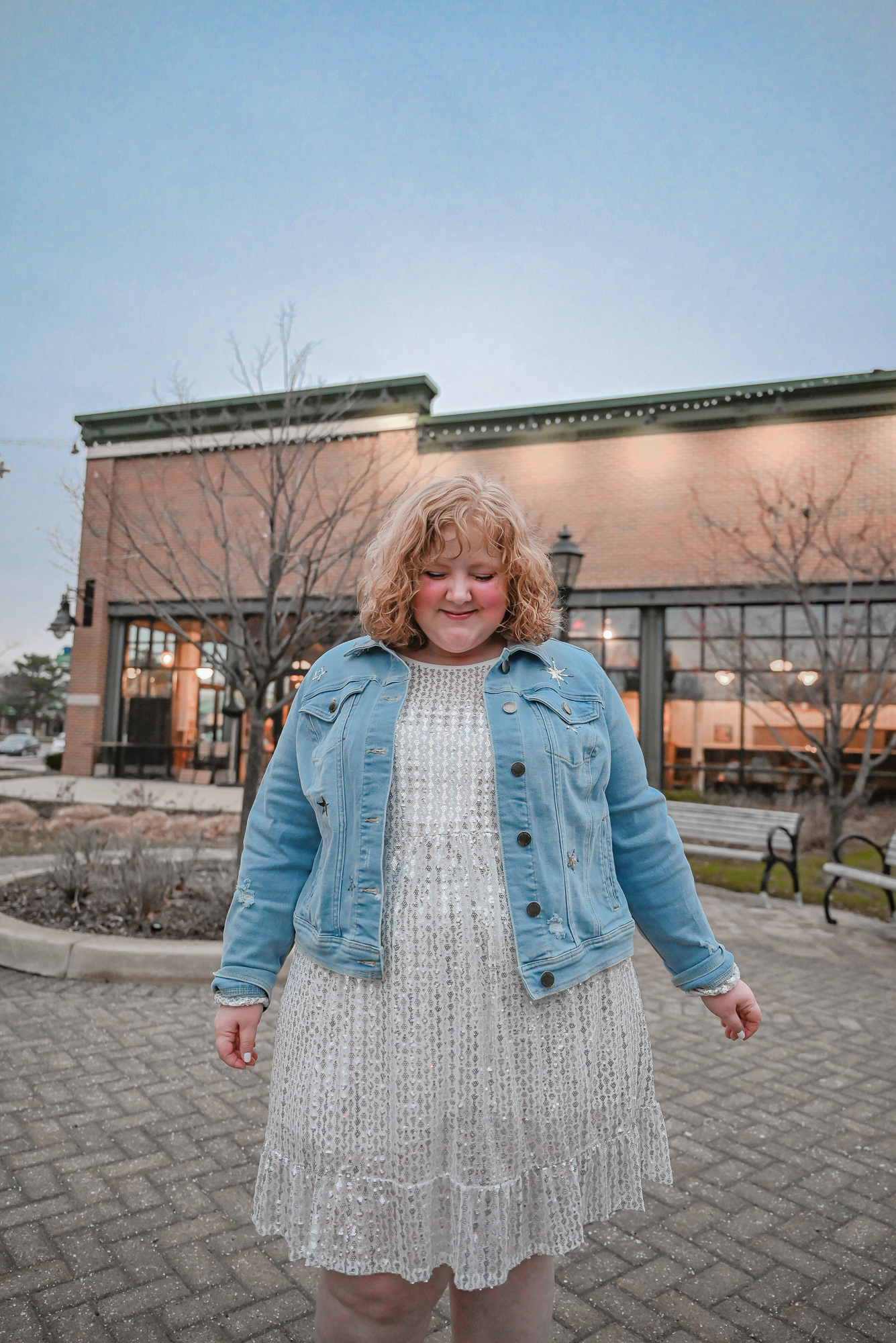 A Holiday Party Outfit Idea: style a sequin party dress with a denim jacket, statement earrings, and ankle boots.