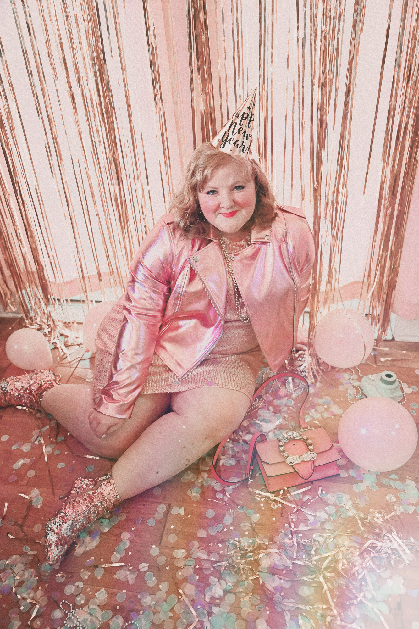 A Pink NYE Photoshoot | Celebrate New Year's Eve at home with a DIY backdrop using tinsel curtains, confetti, balloons, and party beads.